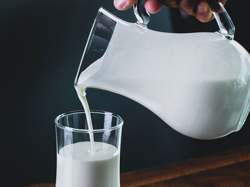 Milk pouring from pitcher to glass