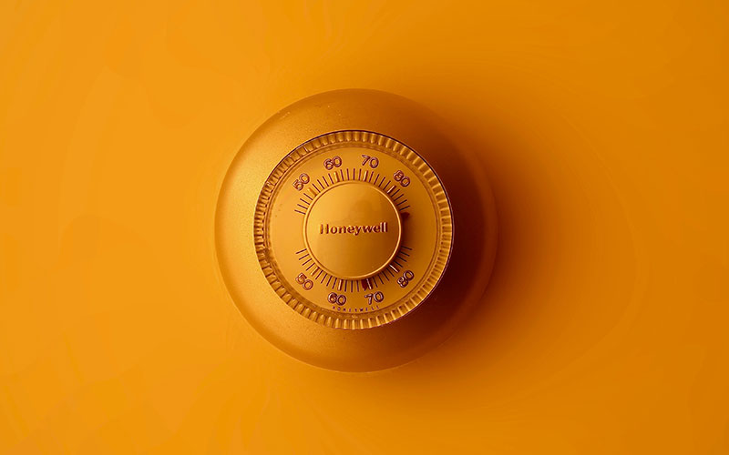 Honeywell thermostat on orange wall