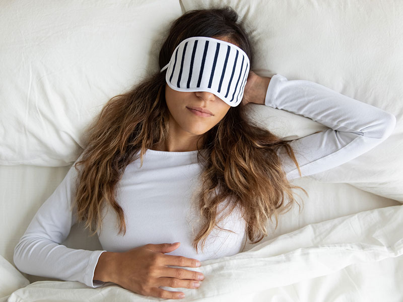 lady wearing sleeping mask, enjoying night dream, napping in comfortable bed